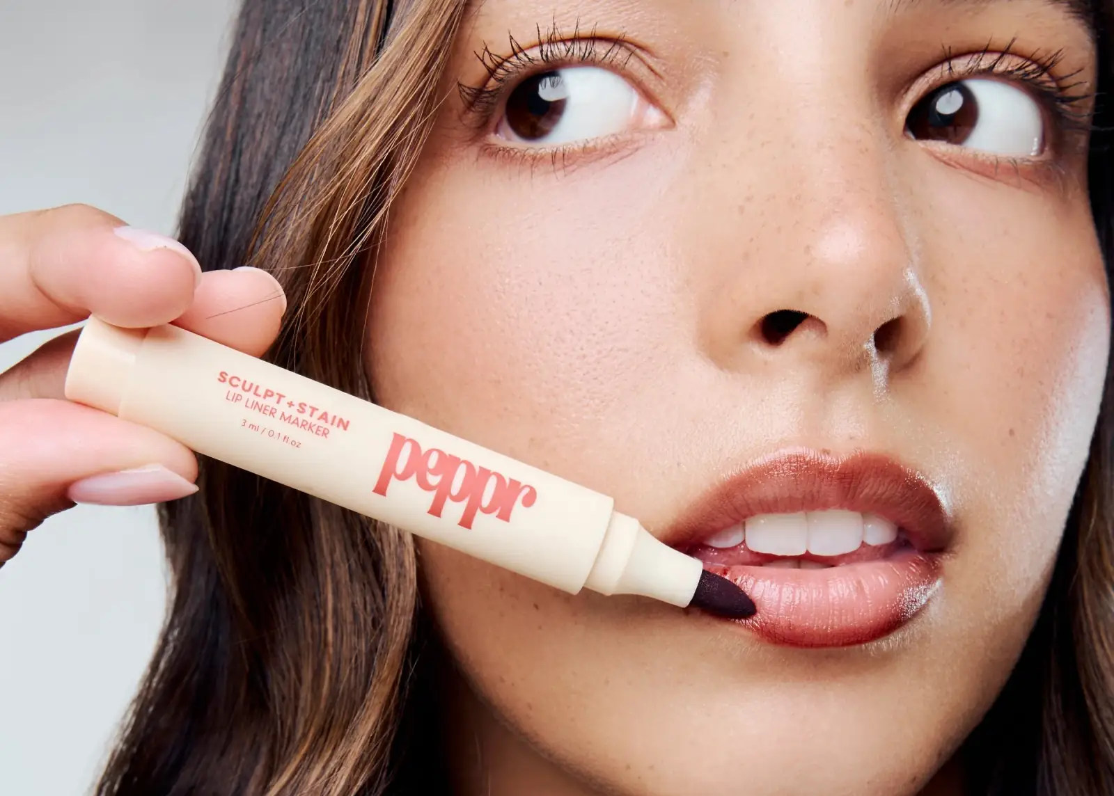 Model applying the Peppr Beauty Sculpt and Stain lip liner marker