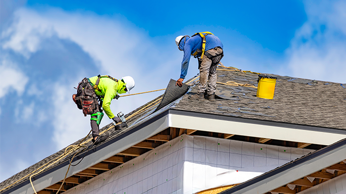 Two roofers working on a roof