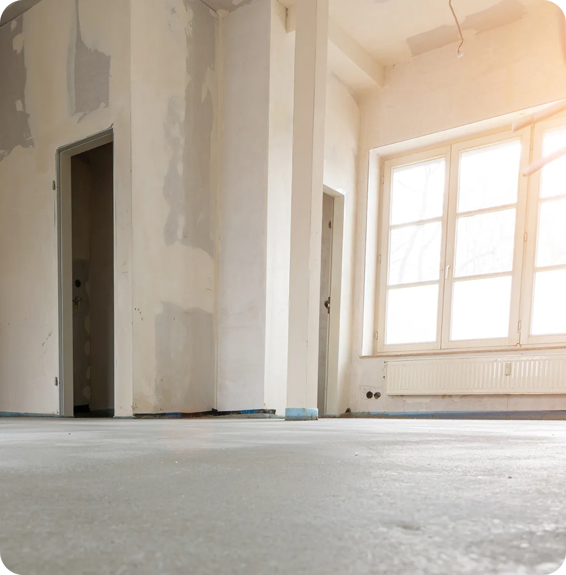 Gärtner trägt grüne Hose und Mütze und schneidet mit einer elektrischen Heckenschere grüne Sträucher.