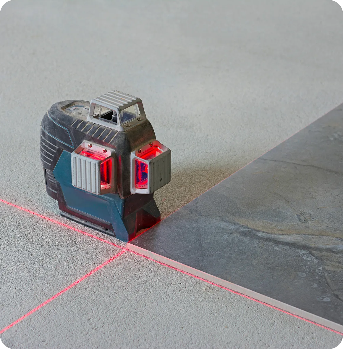 Kreuzlinienlaser auf Boden zur präzisen Ausrichtung von Fliesen.