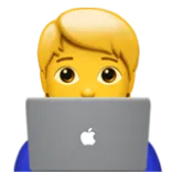 Blond person with short hair using a silver laptop with an apple logo.