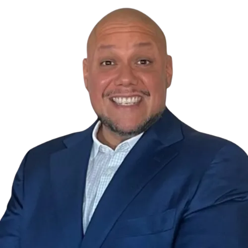 Smiling bald man wearing a blue suit jacket and white shirt against a transparent background.