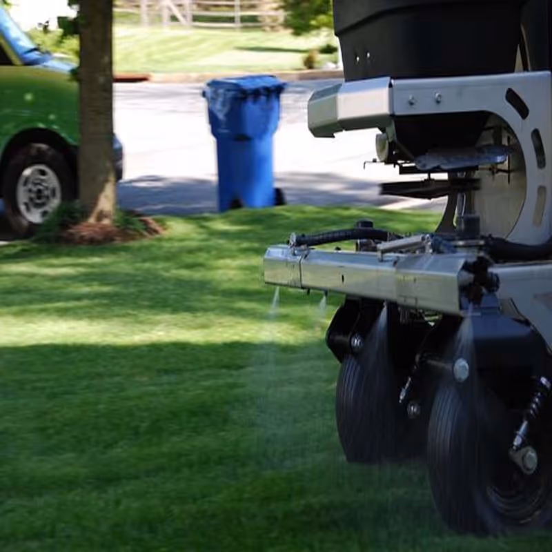 spreading fertilizer on lawn for lawn care service