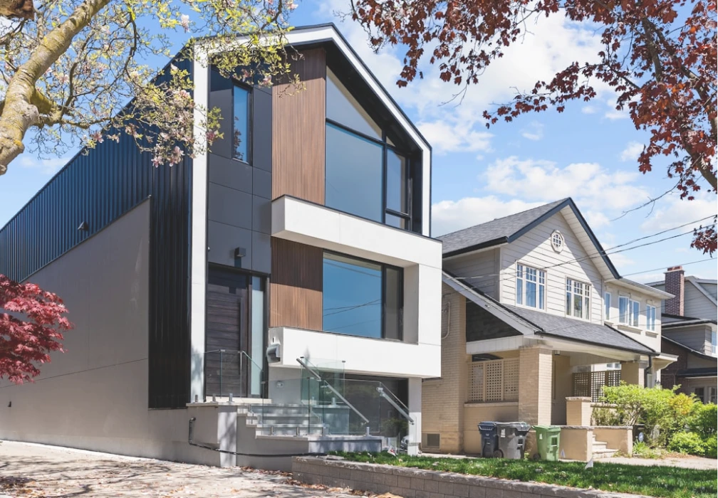 A black and white photograph of a contemporary custom home with distinct geometric architectural features.