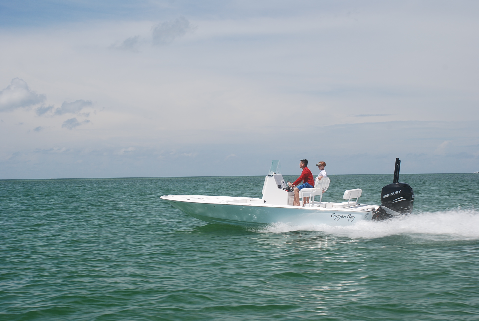 Canyon Bay 24B cruising near sandbar beach