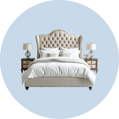Elegant tufted beige upholstered bed with white bedding flanked by two wooden nightstands with lamps.
