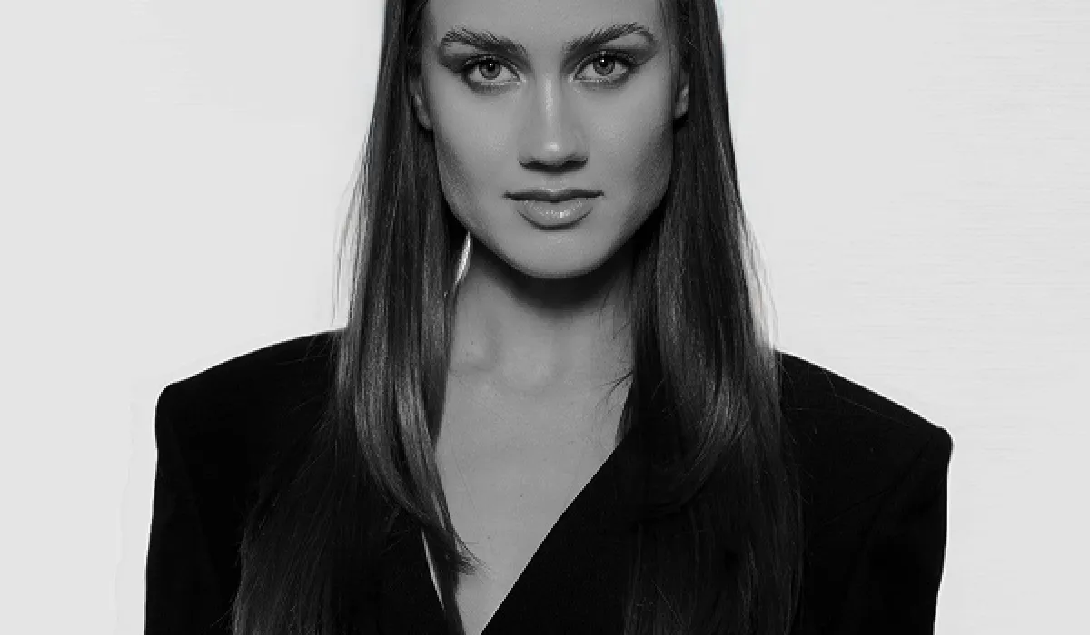 Black and white portrait of a woman with long hair wearing a dark jacket.