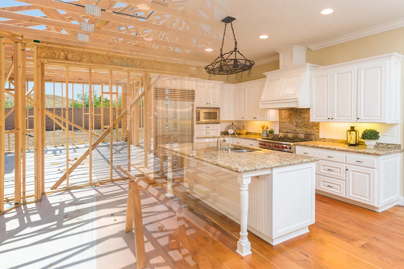 Florida Building Contractors new home kitchen construction in progress with wood framing, partial white cabinet installation, granite island countertop, and stainless steel appliances in a Tampa Bay custom build.