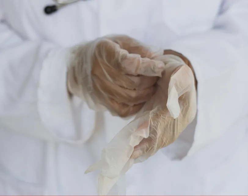 Hands wearing medical gloves being put on for care or protection