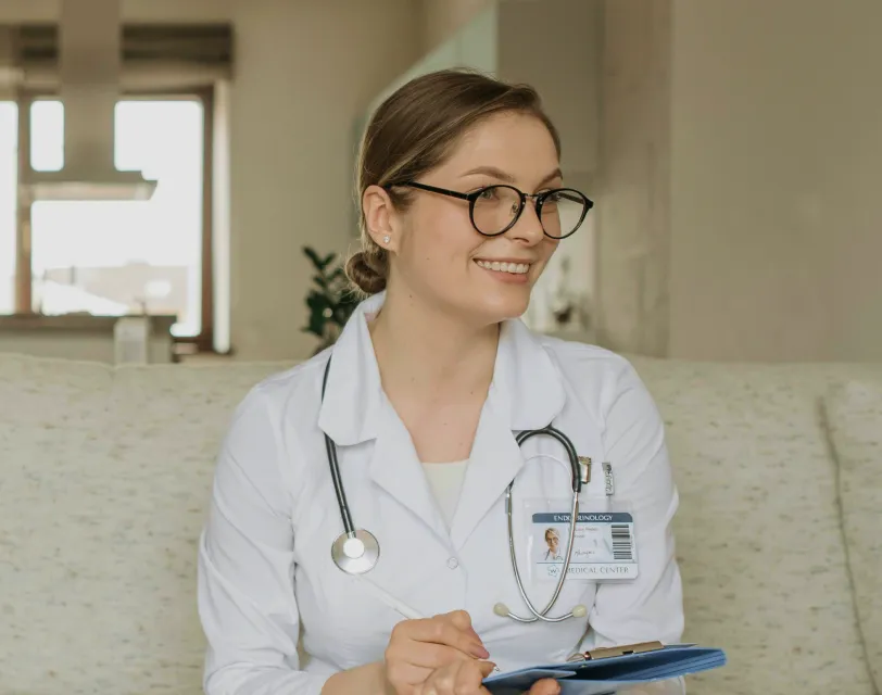 A healthcare professional smiling while holding a clipboard