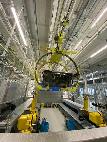 Avtomatizirani sistem za obračanje karoserije avtomobila z rumenimi industrijskimi roboti Fanuc na proizvodni liniji