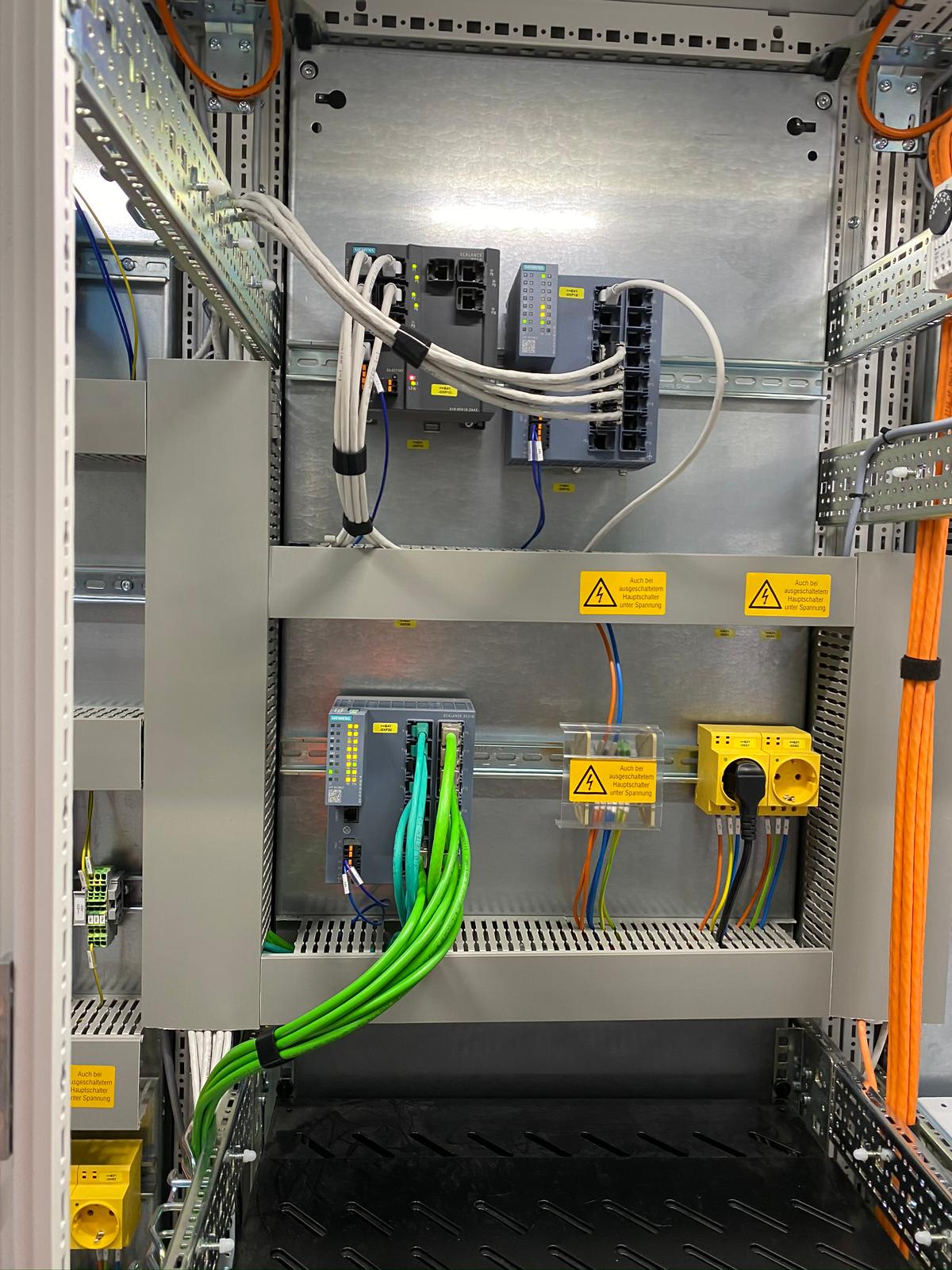 Industrijski razvodna omara s Siemens PROFINET omrežnimi stikali, PLC krmilnim modulom in večbarvnimi kabelskimi instalacijami