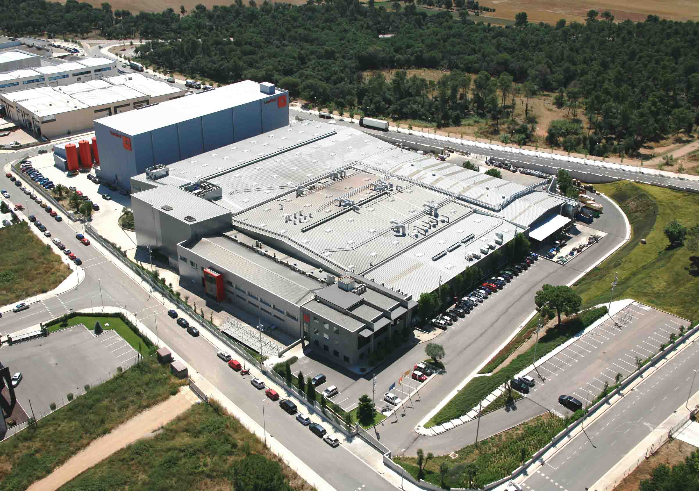 Kabelski most z množico sivih in zelenih PROFINET kablov v industrijski hali z rdečo jekleno konstrukcijo