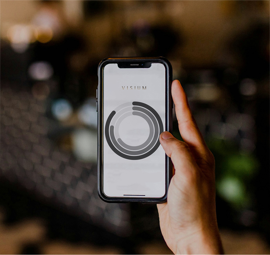 Dłoń trzyma telefon komórkowy i pokazuje ekran na którym znajduje się wykres przykładowych danych finansowych spółki