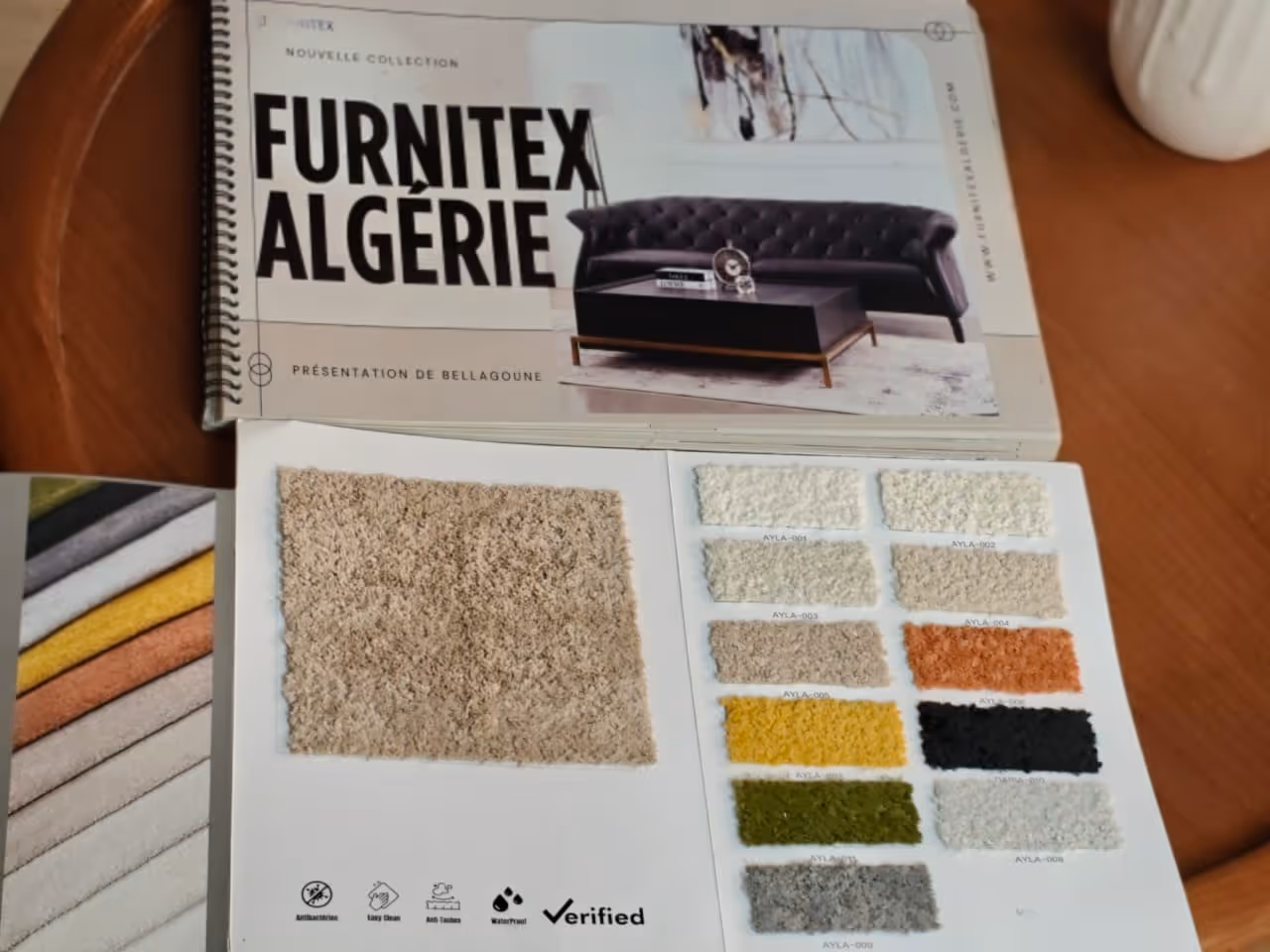 Canapé beige en cuir capitonné avec deux coussins, un orange et un beige, dans un salon moderne.