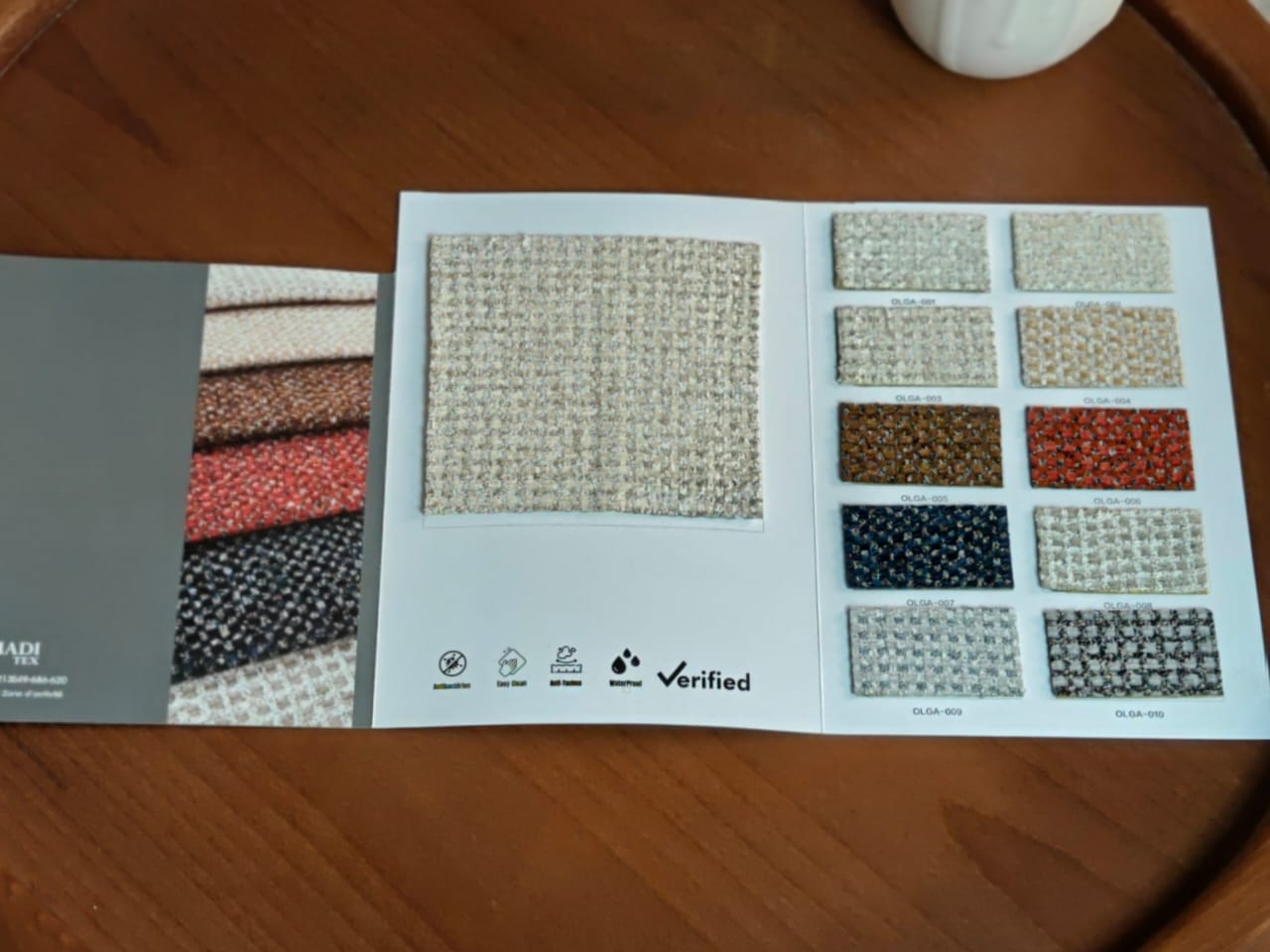 Canapé modulable blanc en tissu chenille avec coussins dans une pièce aux murs clairs et sol bois.