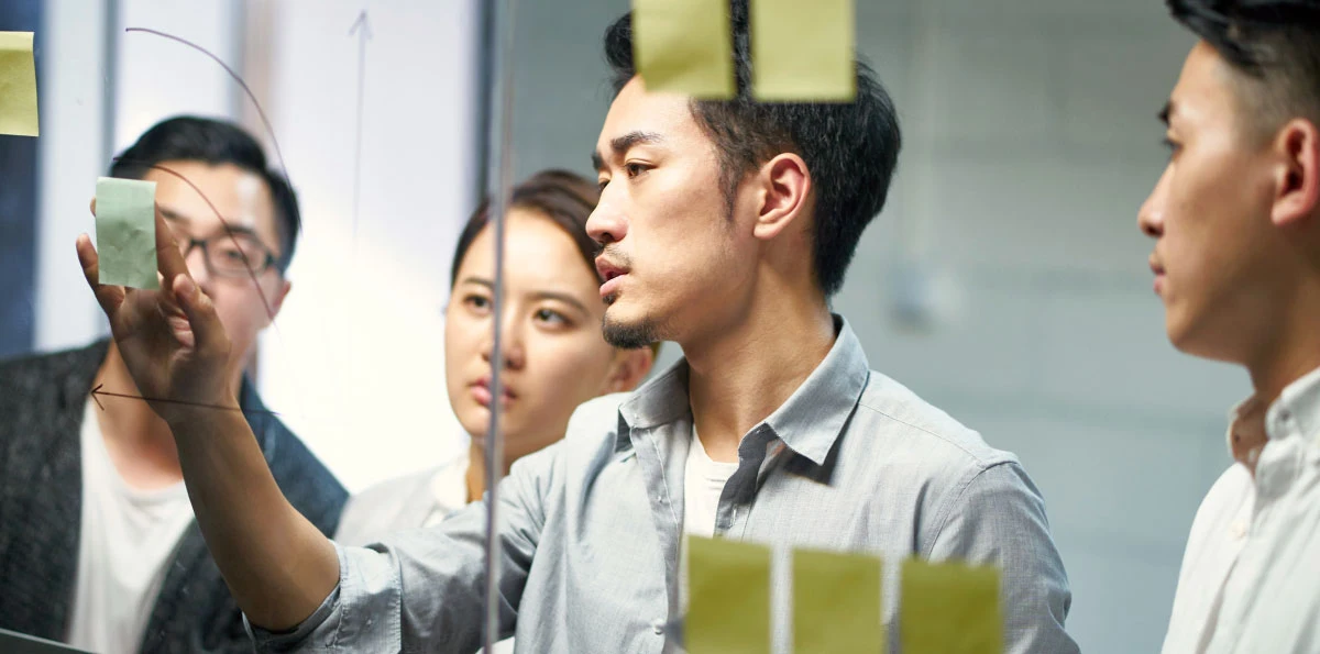 people focusing on sticky notes