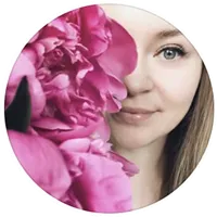 Close-up of a woman partially hidden behind large pink peony flowers, showing one eye and part of her face.