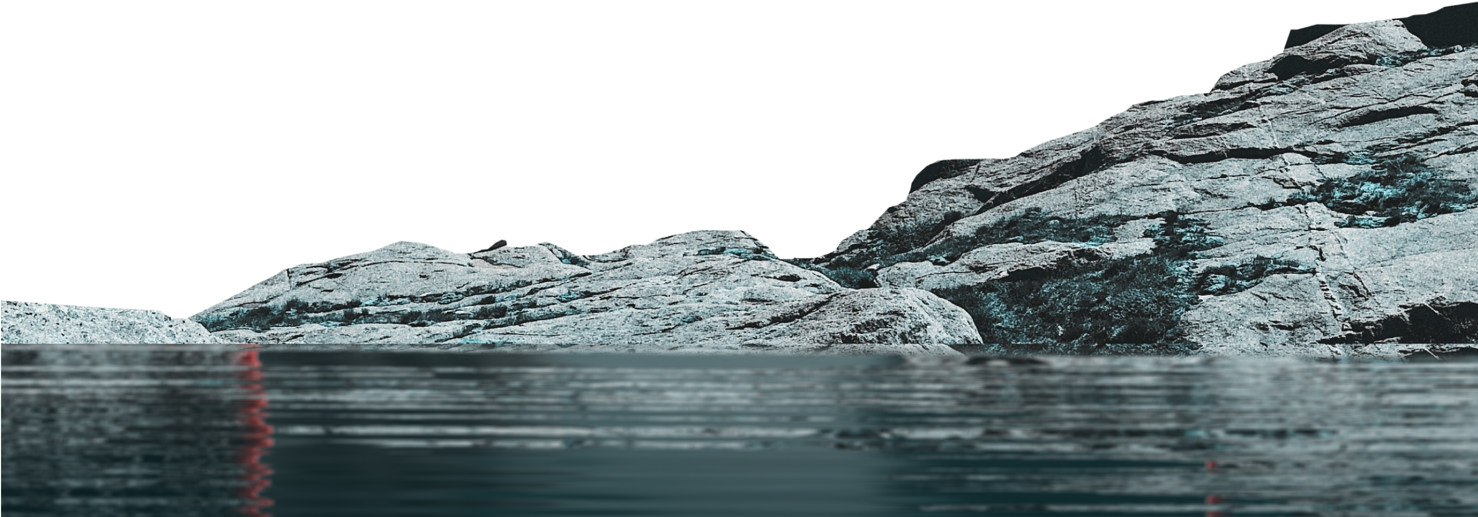 Rocky shoreline with large, textured gray rocks reflected in calm water.