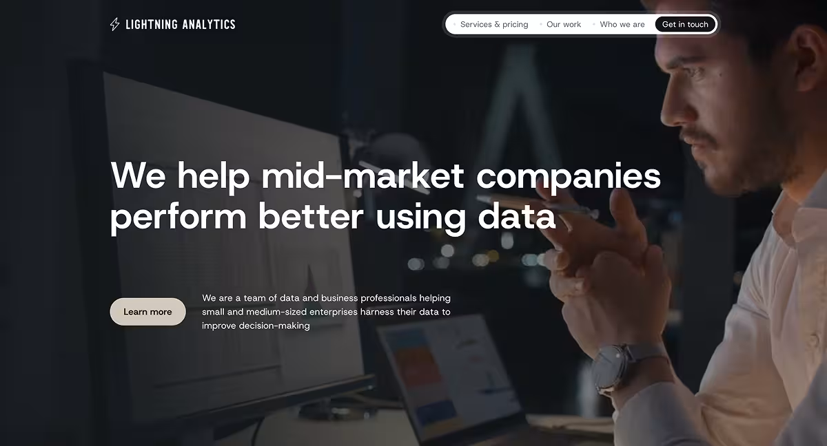 Man in white shirt working late on a computer with data visuals, website header text about helping companies.