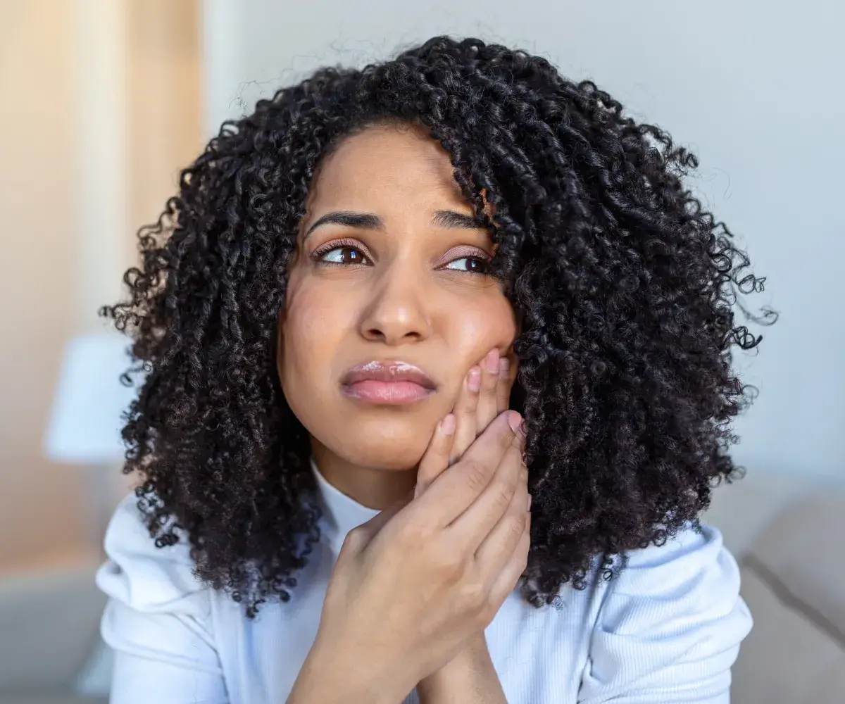 A close up of a person with curly hair.