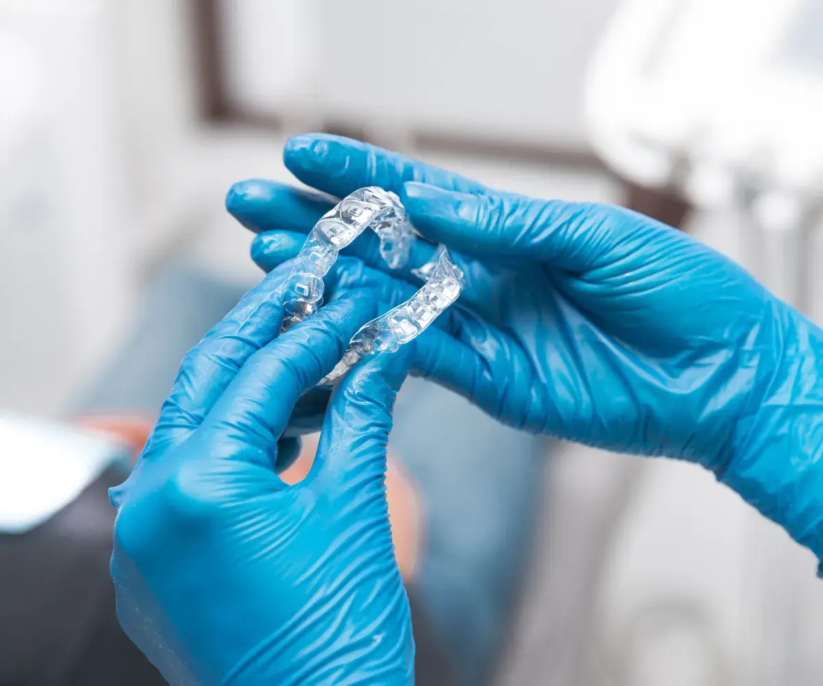 A person in blue gloves holding a ring.