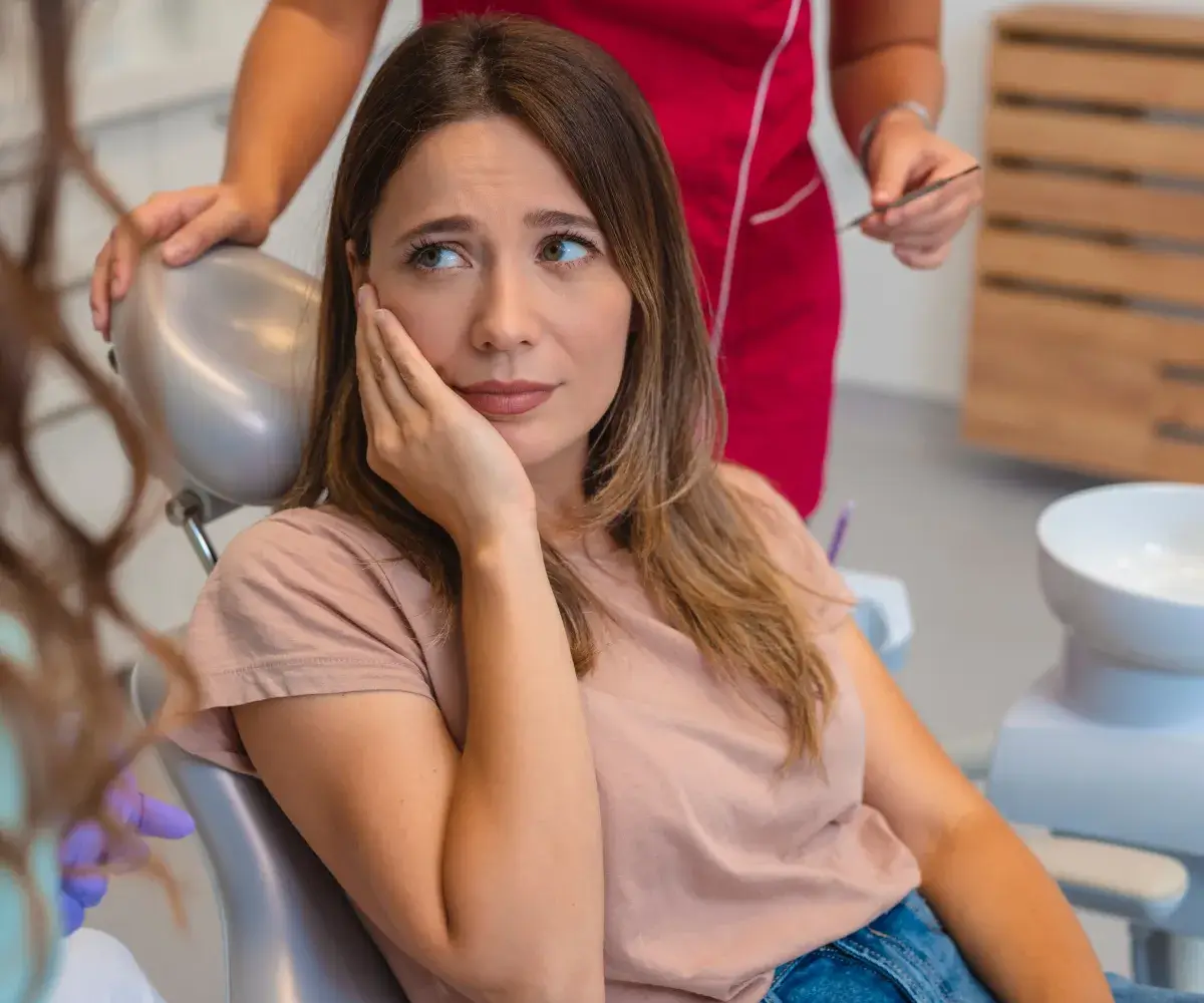 A woman sitting in a chair with a hair dryer.