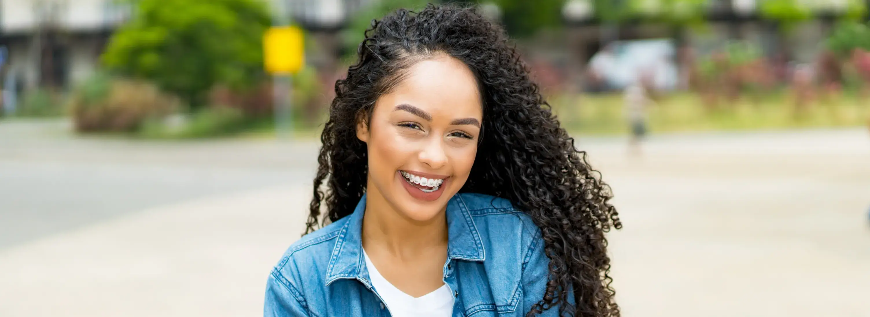 A woman with curly hair smiling at the camera.
