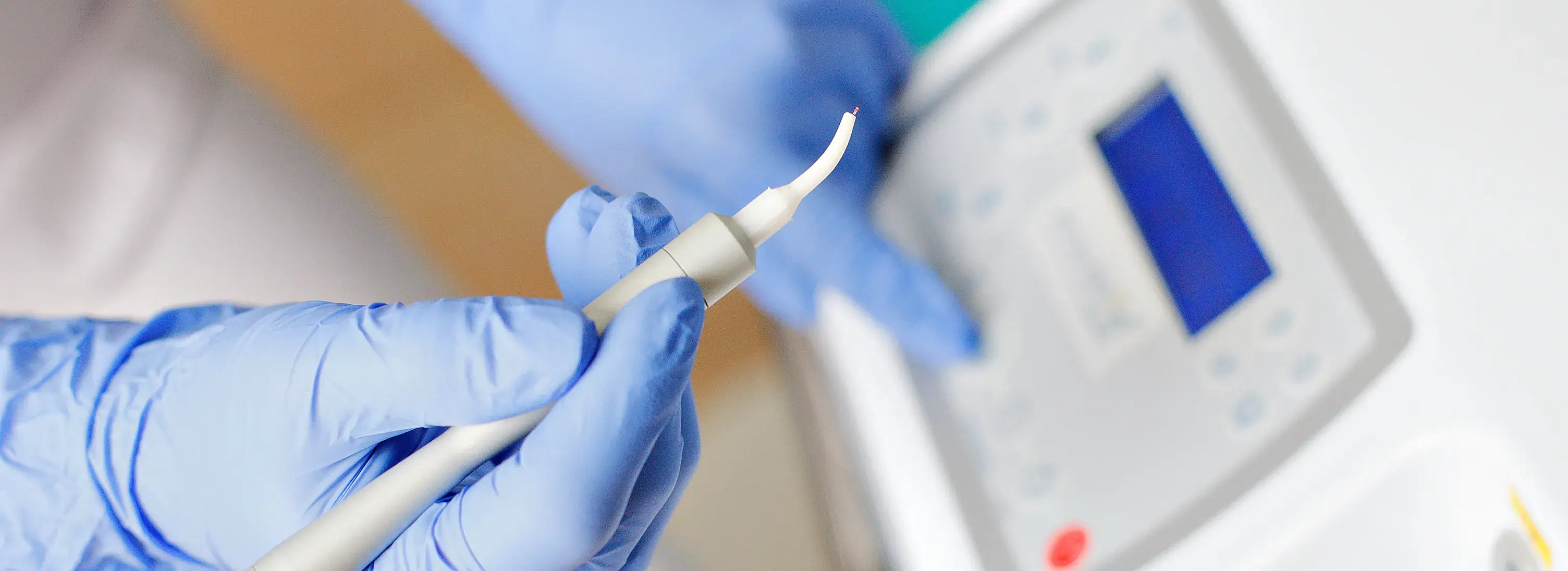 A person in blue gloves and gloves holding a toothbrush.