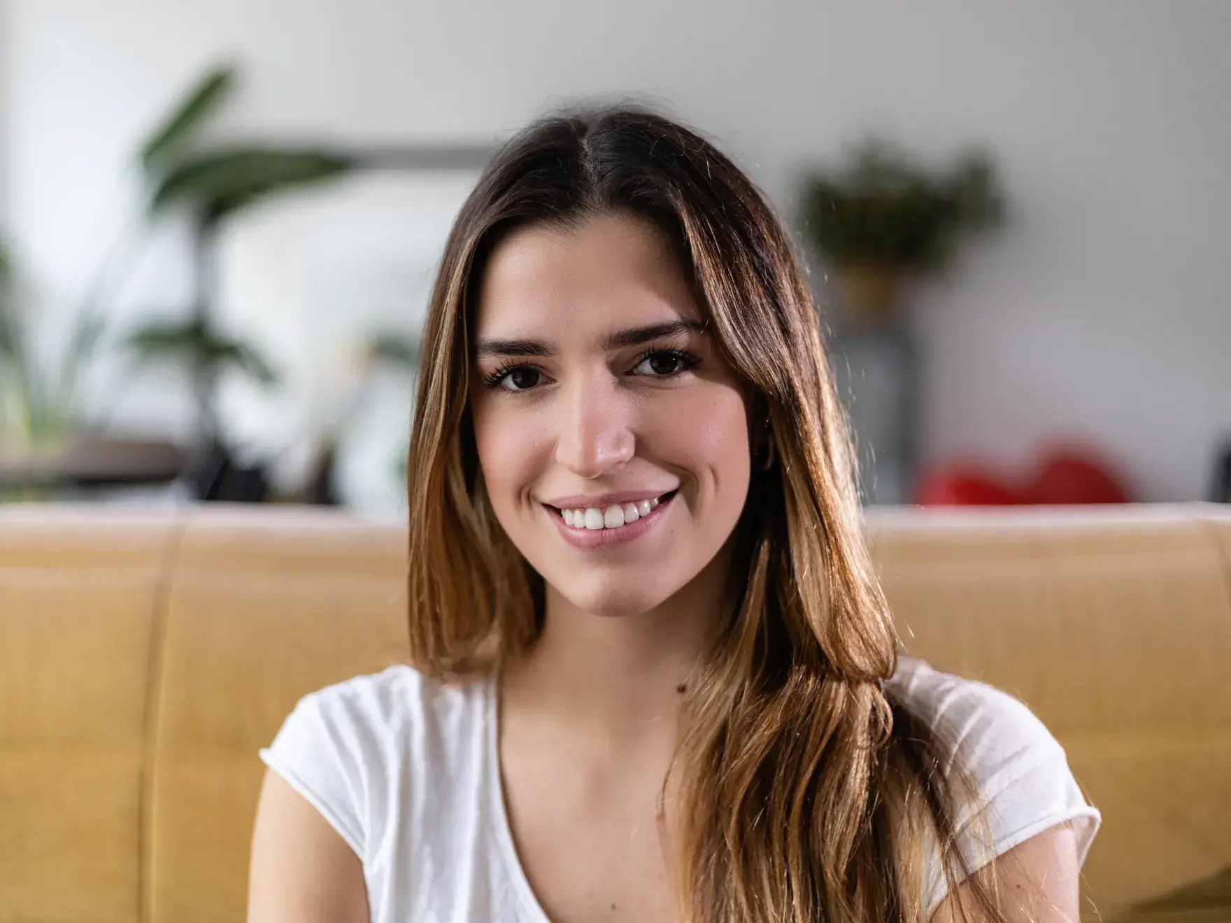 A woman sitting on a couch with a smile on her face.