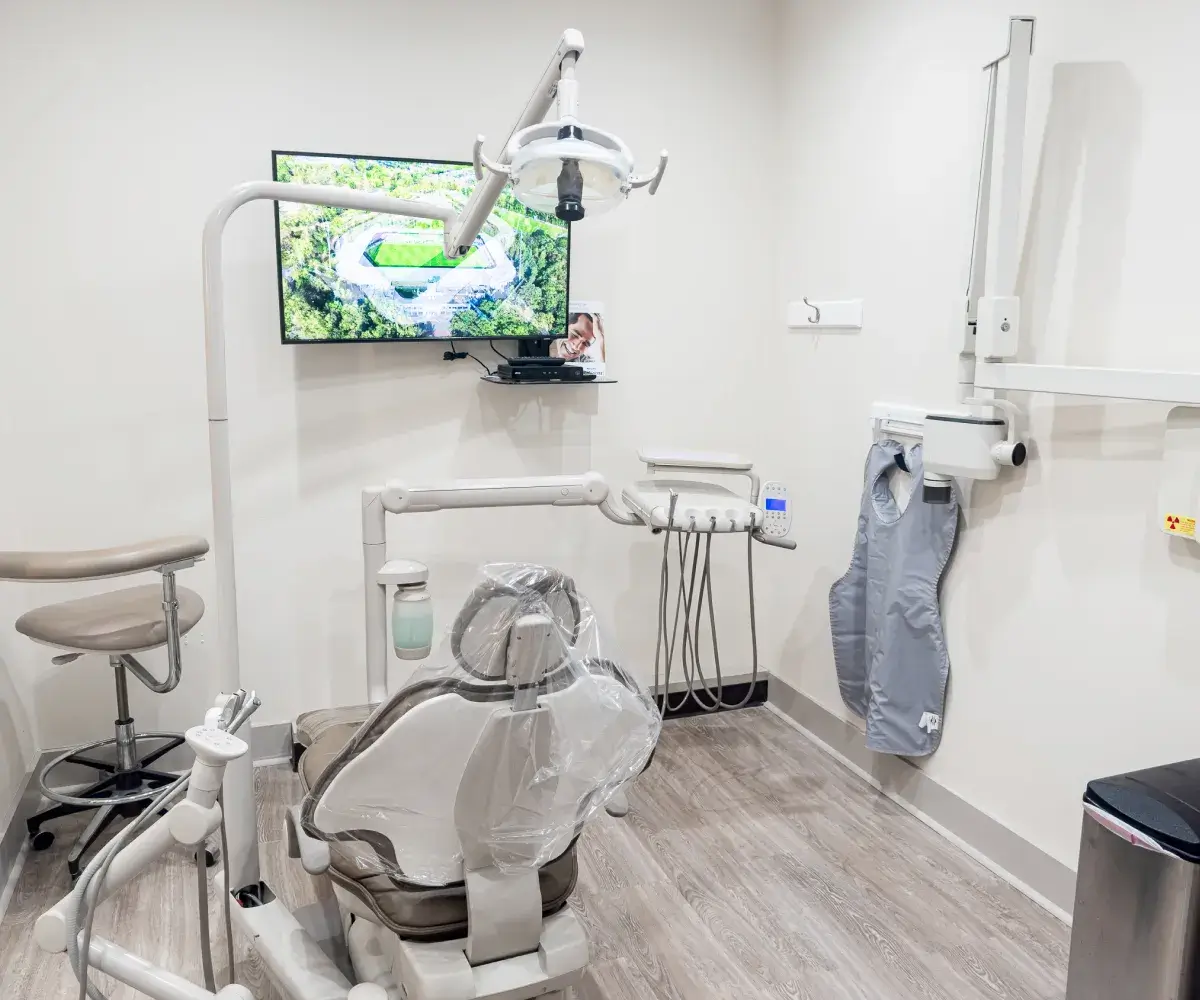 A dental room with dental equipment and a flat screen tv.