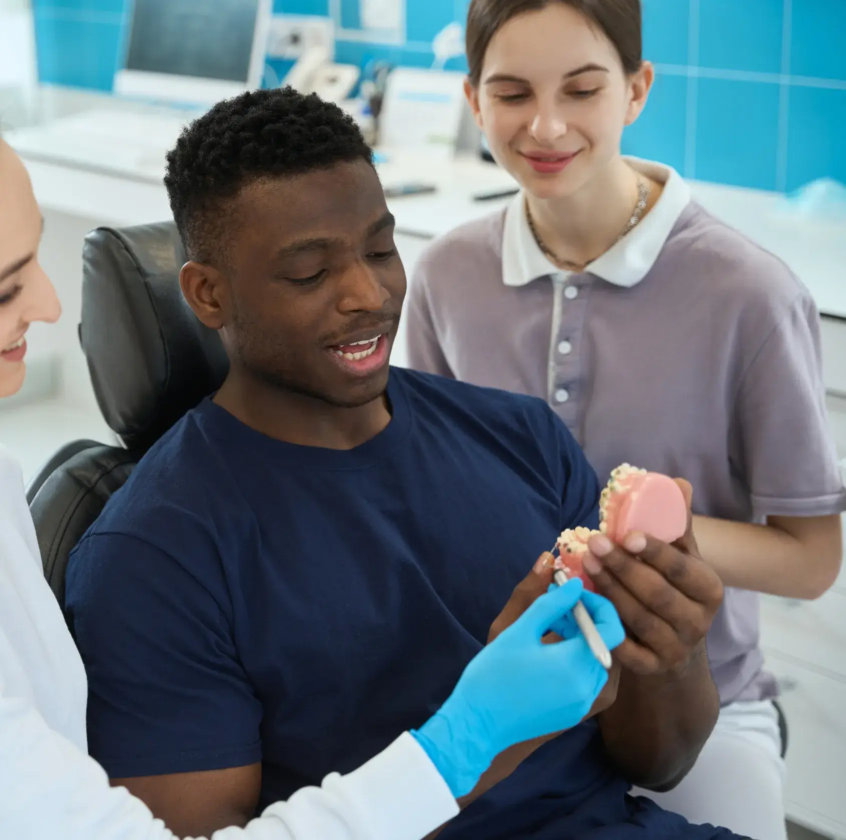 A man in a dentist's chair holding a toothbrush.