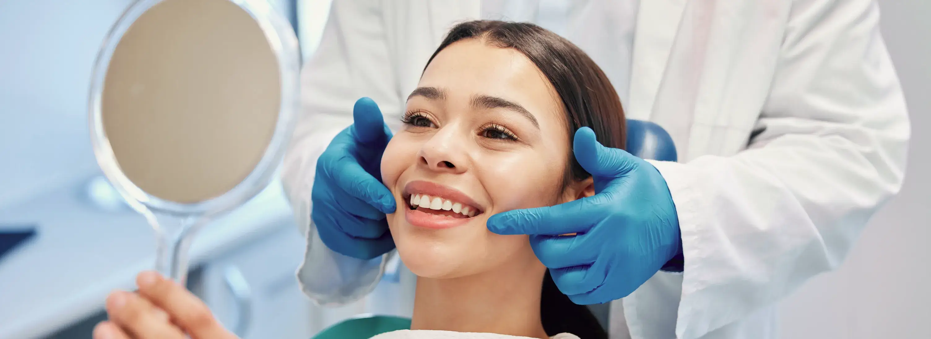 A woman getting her teeth brushed by a dentist.