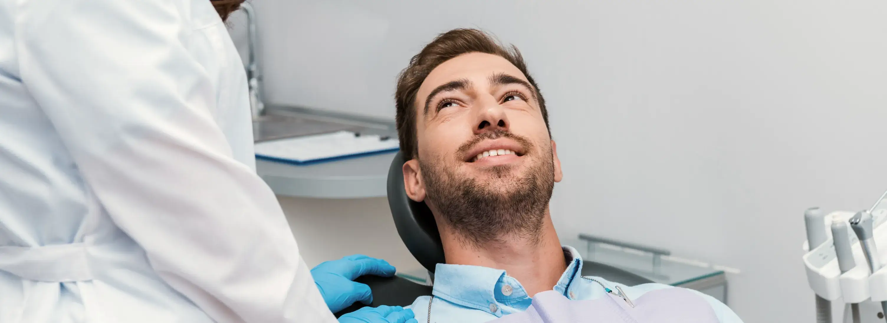 A man getting his teeth checked by a dentist.