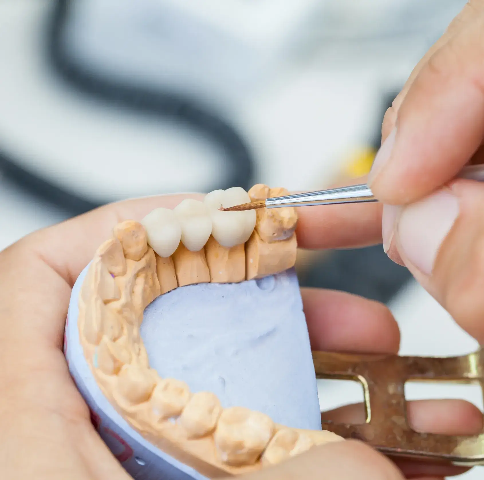 A person cutting a tooth with a pair of scissors.