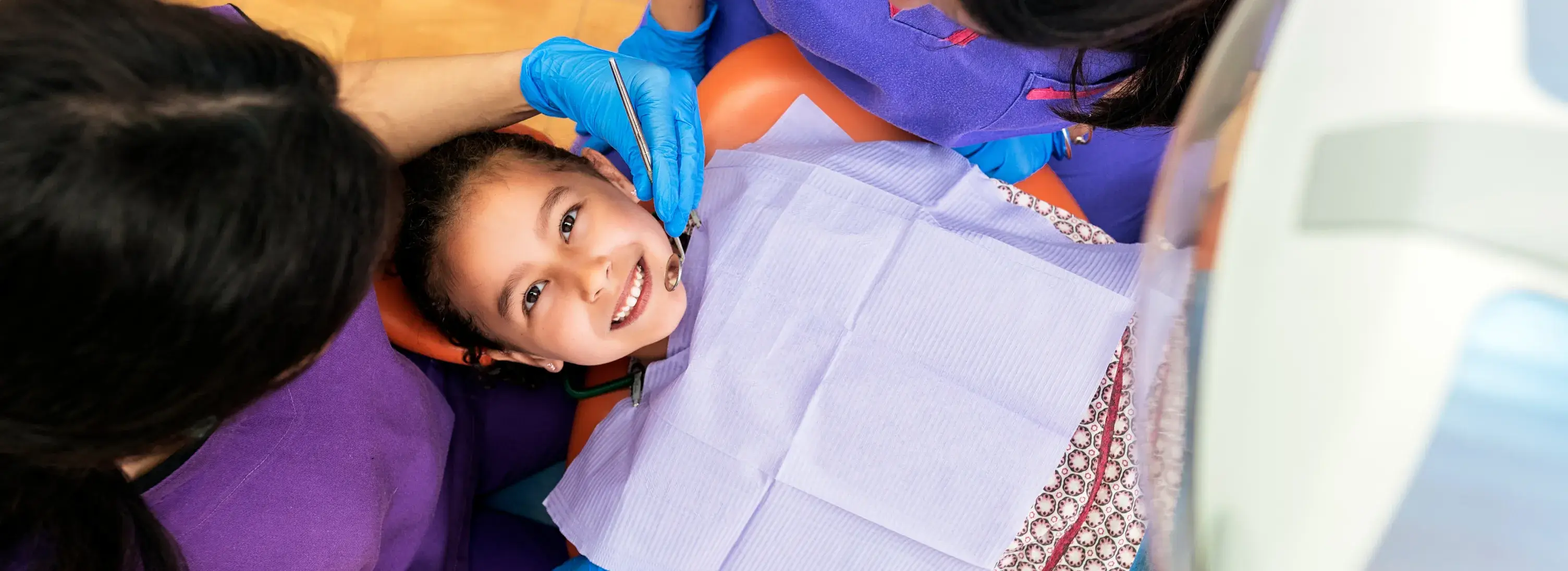 A young girl getting her hair cut by a woman.