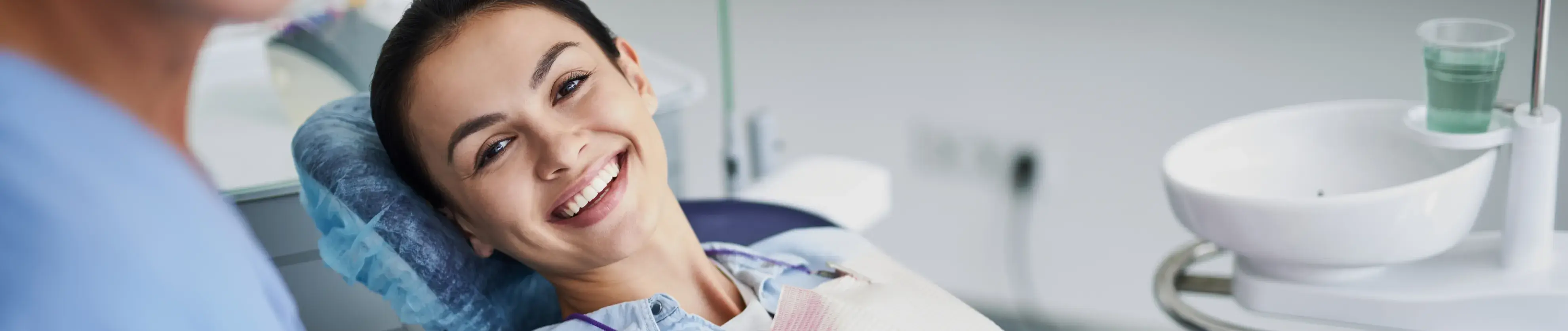 a woman sitting in a dentist chair smiling