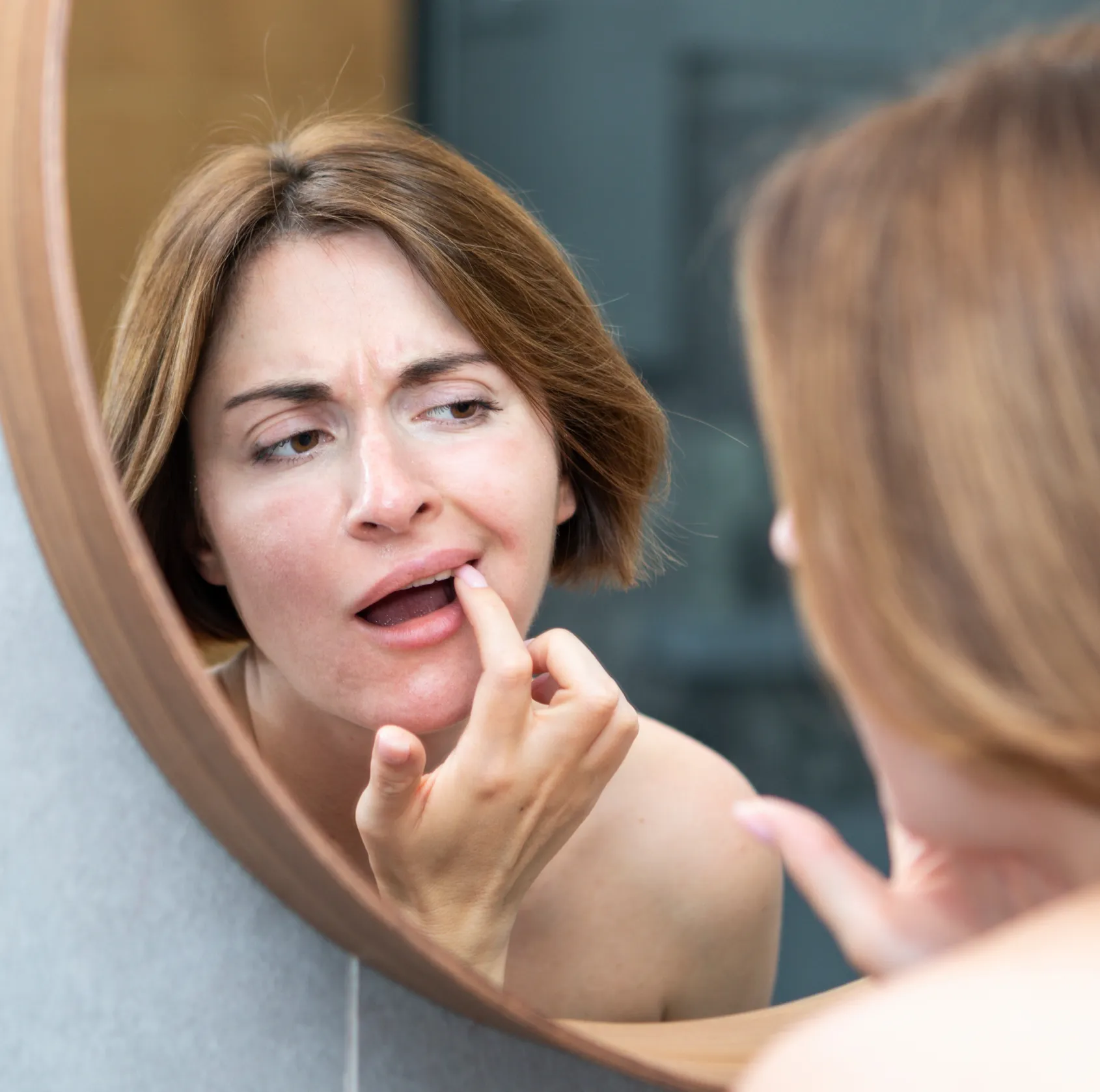 Woman checking her teeth in the mirror