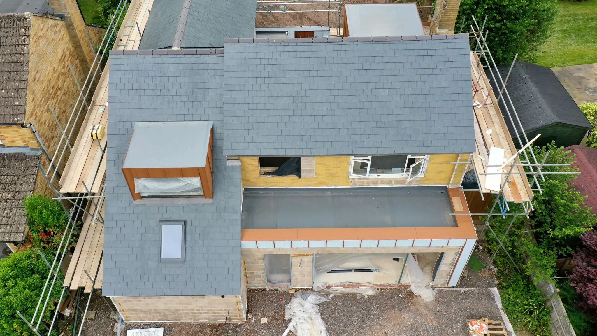 A rear extension with a flat roof and new slate pitched roof above