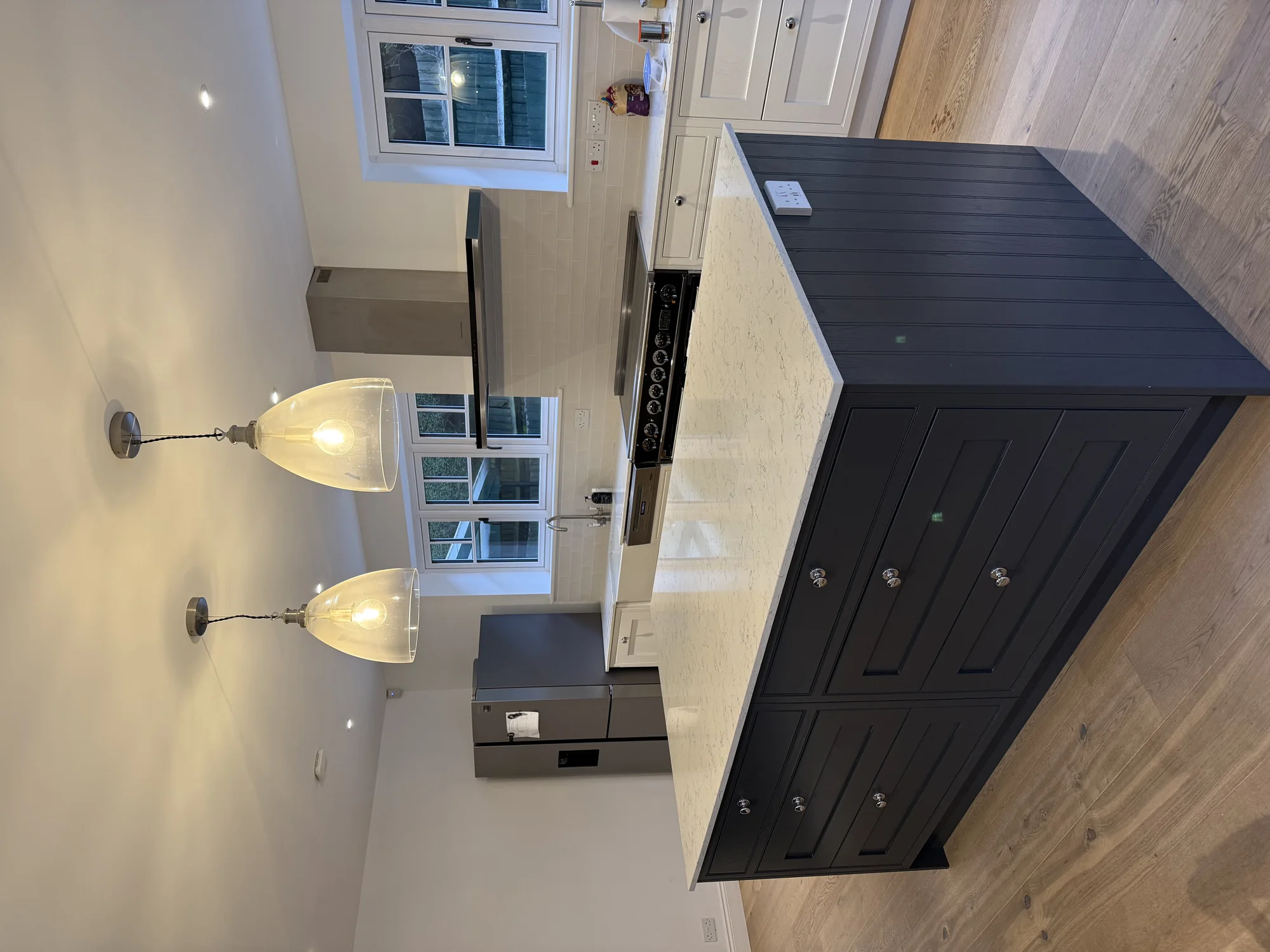 A finished kitchen by Morco Construction with a navy island, quartz worktop and range cooker