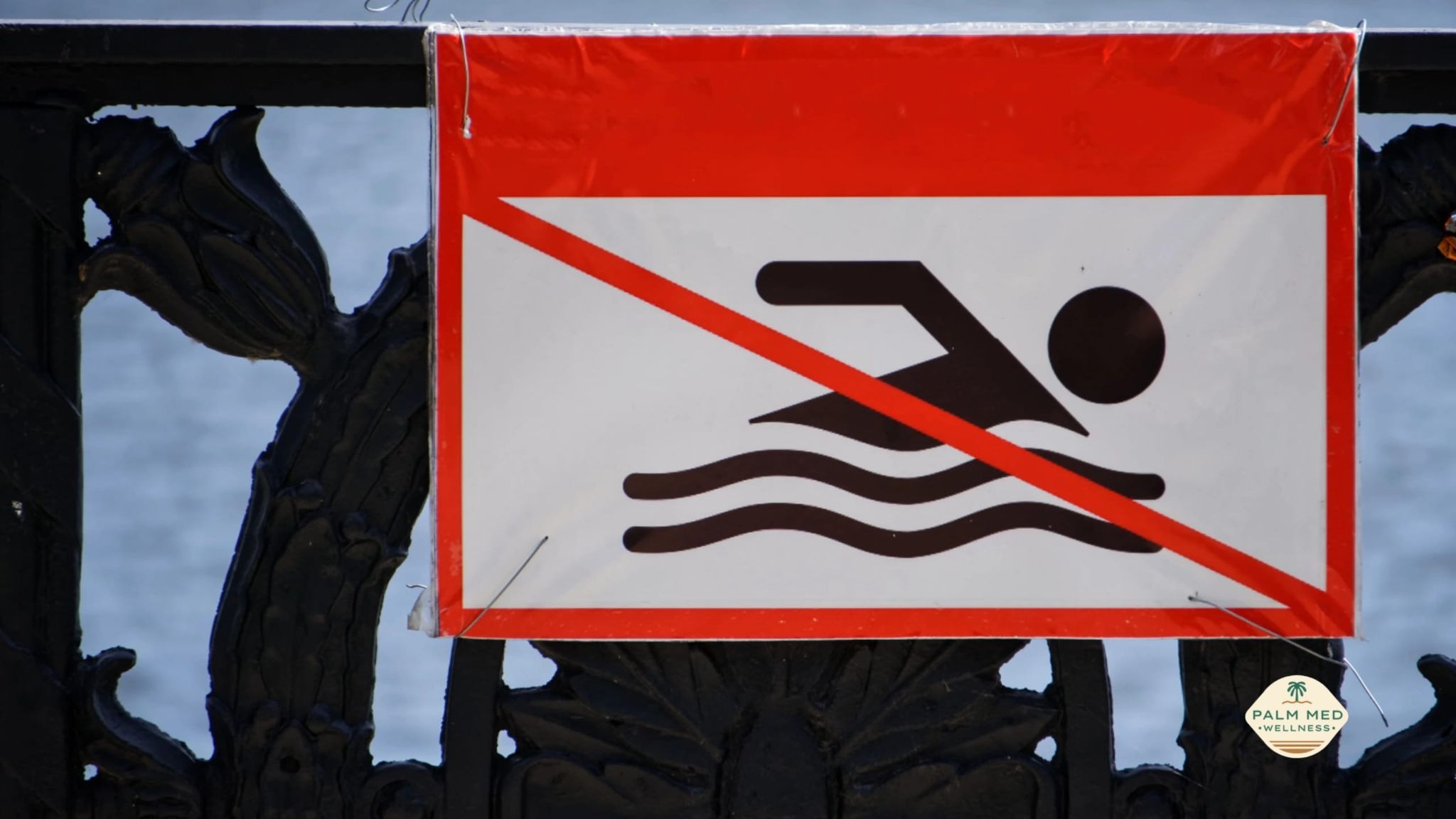 A sign displaying "No Swimming" with a clear red circle and line through a swimmer icon.