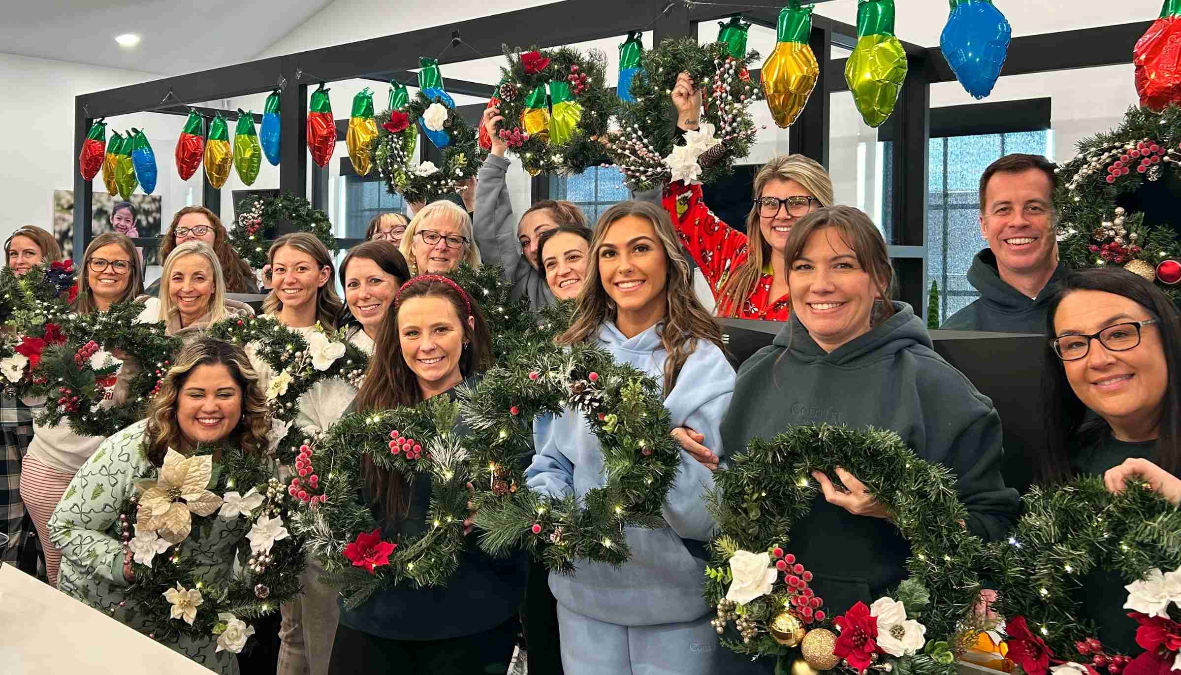 Zoom video call grid of multiple people smiling and holding paintings of colorful butterflies.