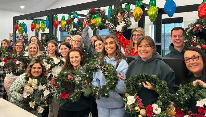 Zoom video call grid of multiple people smiling and holding paintings of colorful butterflies.