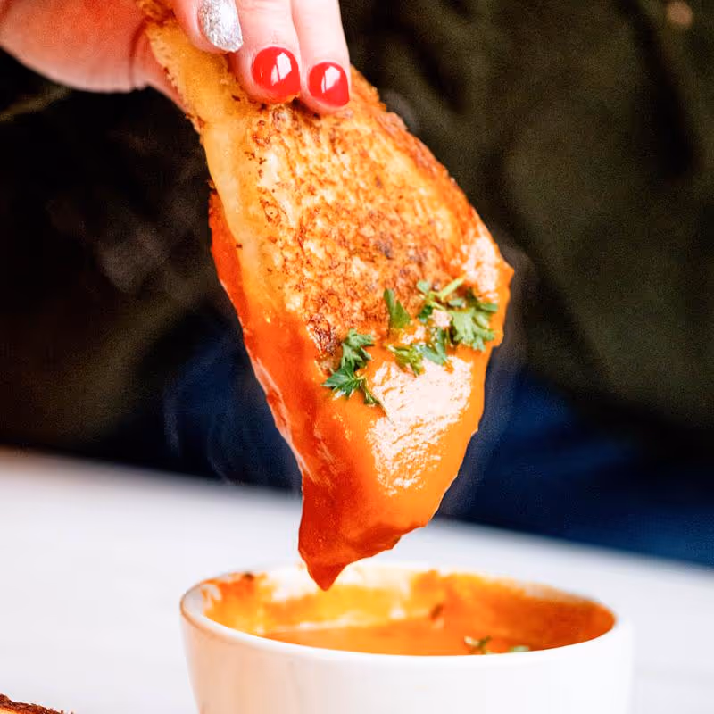 A person is pouring sauce into a bowl.