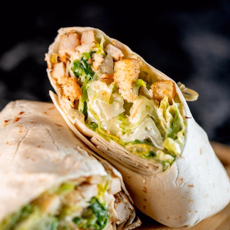 A burrito cut in half with meat and vegetables
