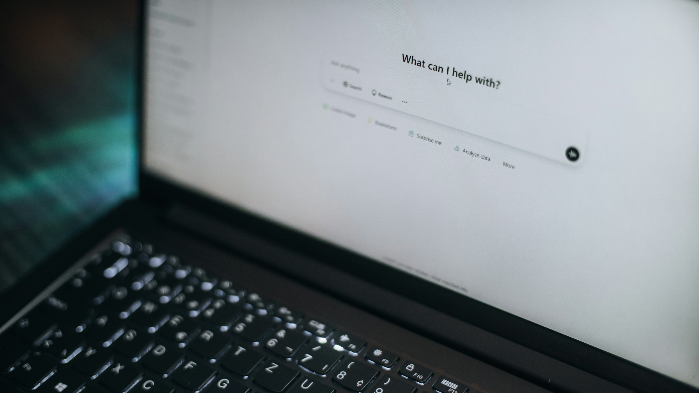 A laptop screen displaying an AI assistant asking what can I help with