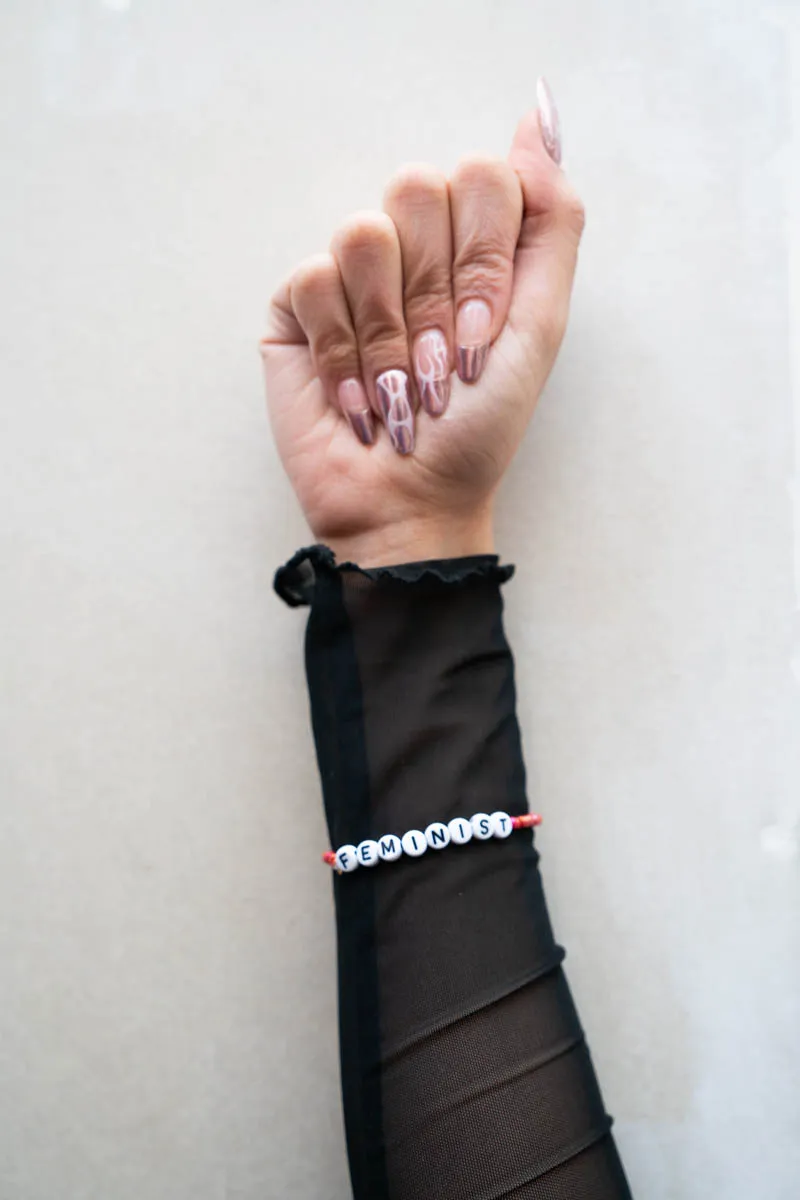 Hand macht Faust mit Feminist Armband
