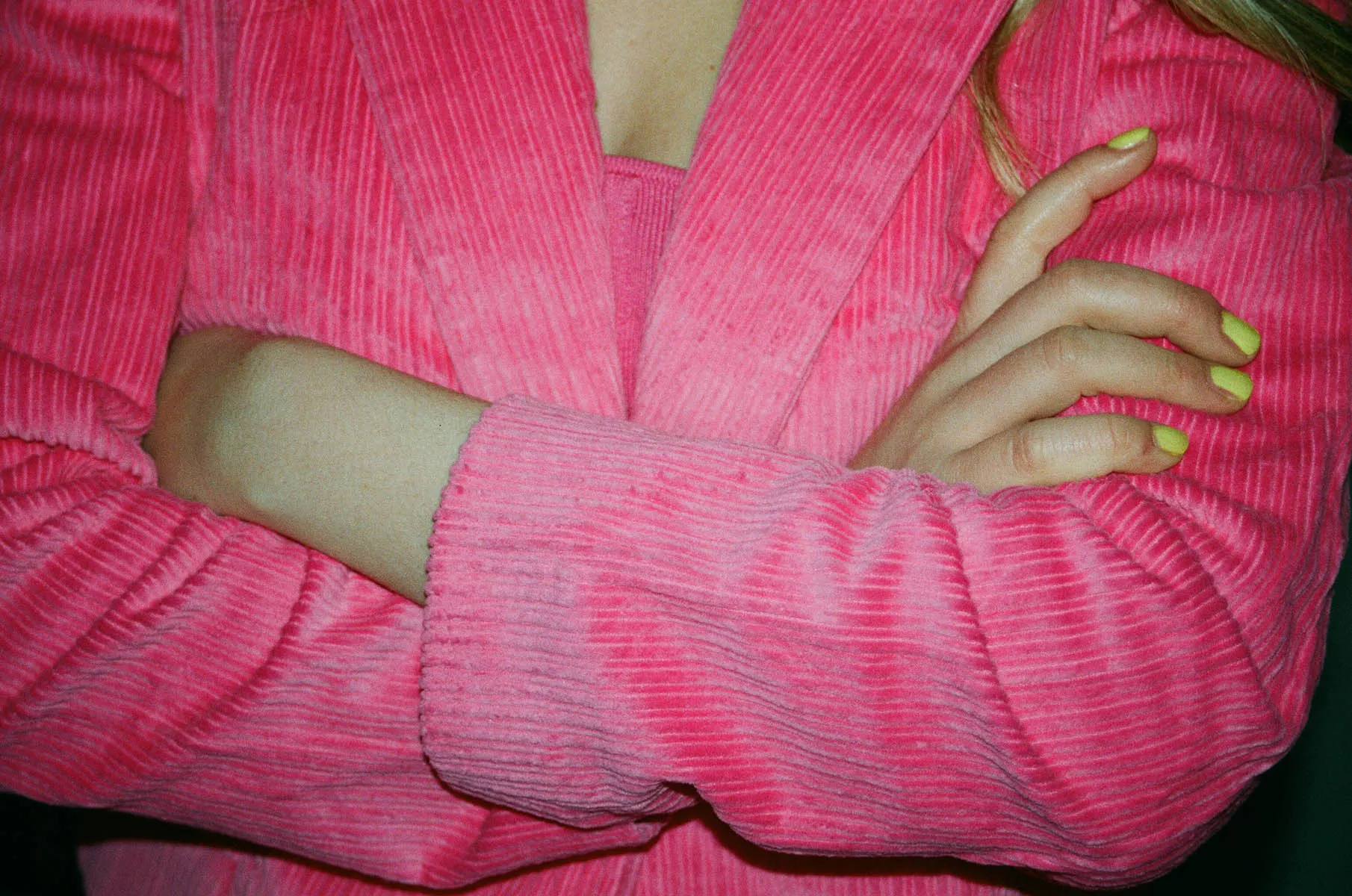 Frau in pinkem Blazer verschränkt Arme