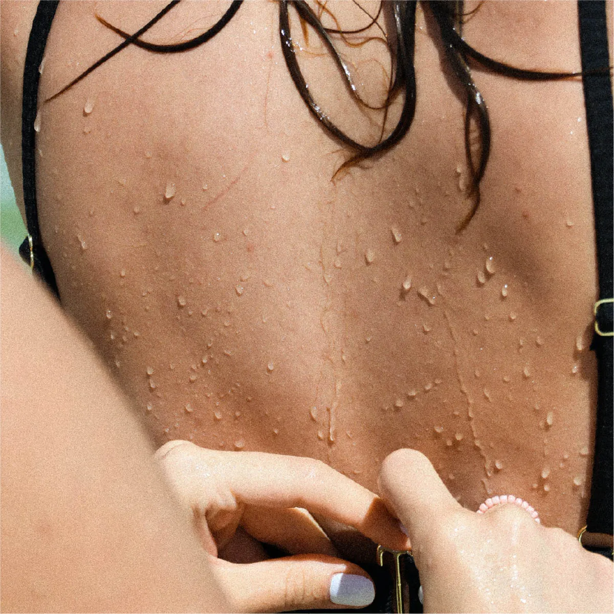 Frau schließt anderen Frau den Bikini