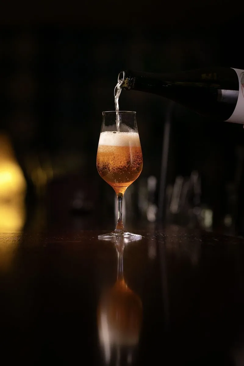 A glass of beer being poured into it